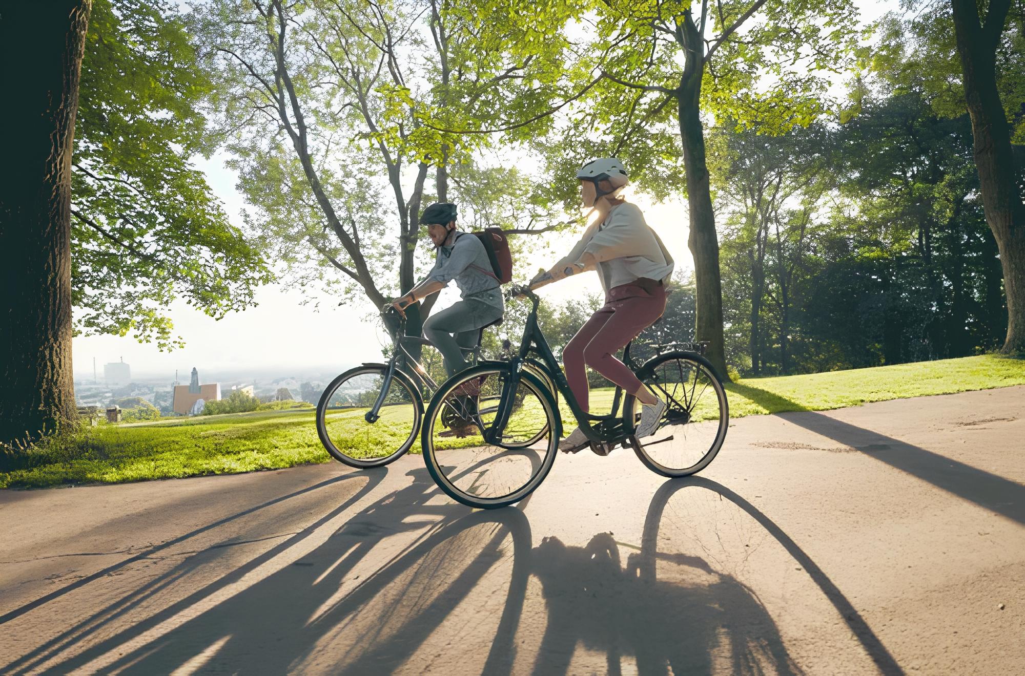 Eine dreiköpfige Familie fährt auf Fahrrädern vor einem modernen Glasgebäude, in dem sich Bäume und Fahrräder spiegeln.
